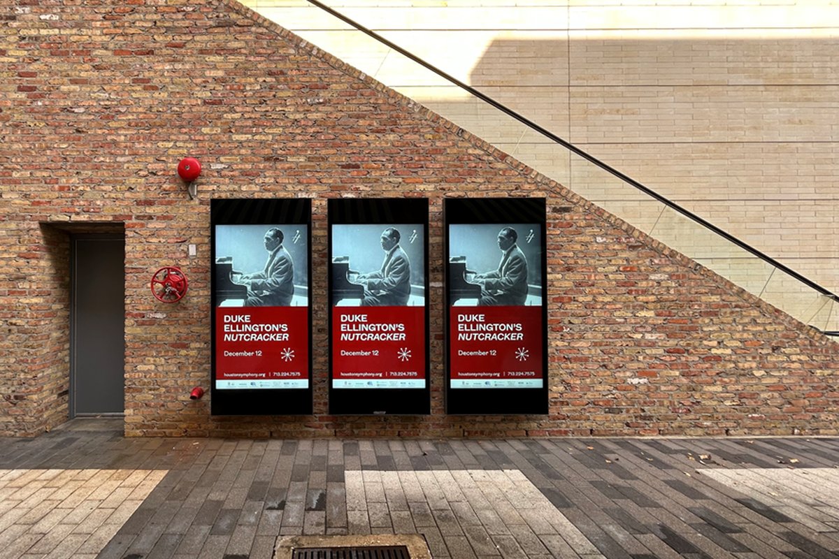 Three portrait LCD screens running promotions on a shopping-mall wall